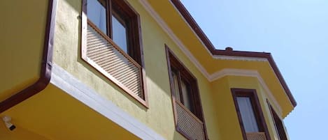 Un edificio amarillo con varias ventanas y balcones.