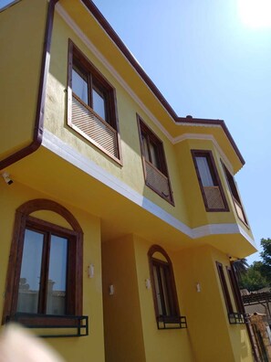 Un edificio amarillo con varias ventanas y balcones.