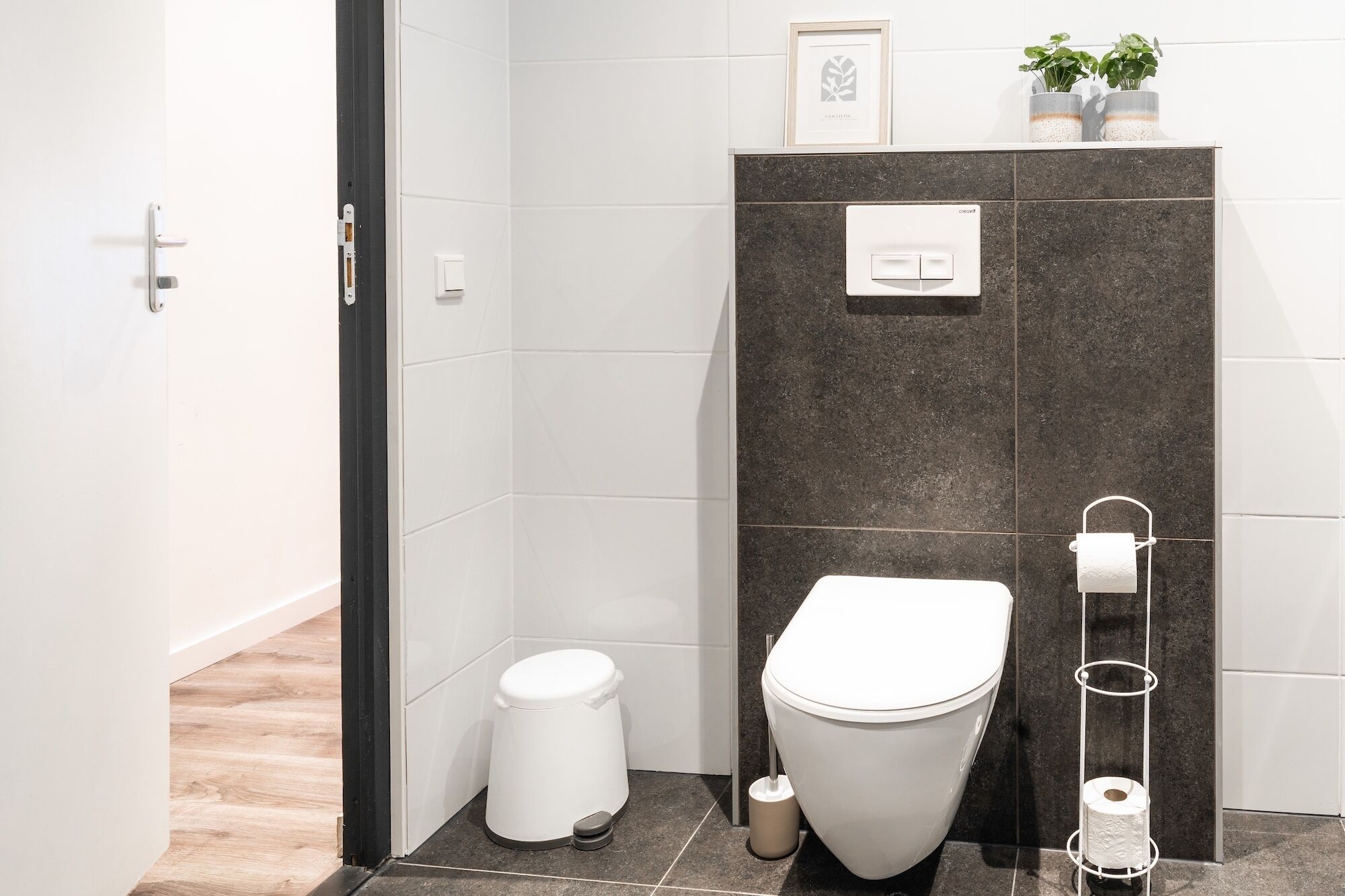 Um banheiro moderno com vaso sanitário, bidê e suporte para papel higiênico.