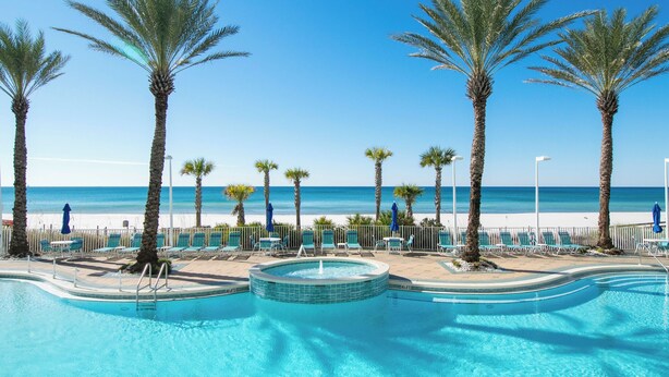 A pool area with a clear view of the beach and ocean.