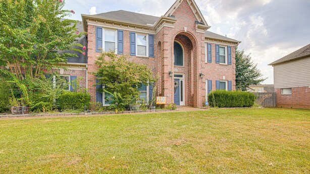 A two-story brick house with a front entrance, a small front yard, and a sign that reads "Peace." - Residential Cul-de-sac: Suburban Memphis Hideaway! (Cordova)