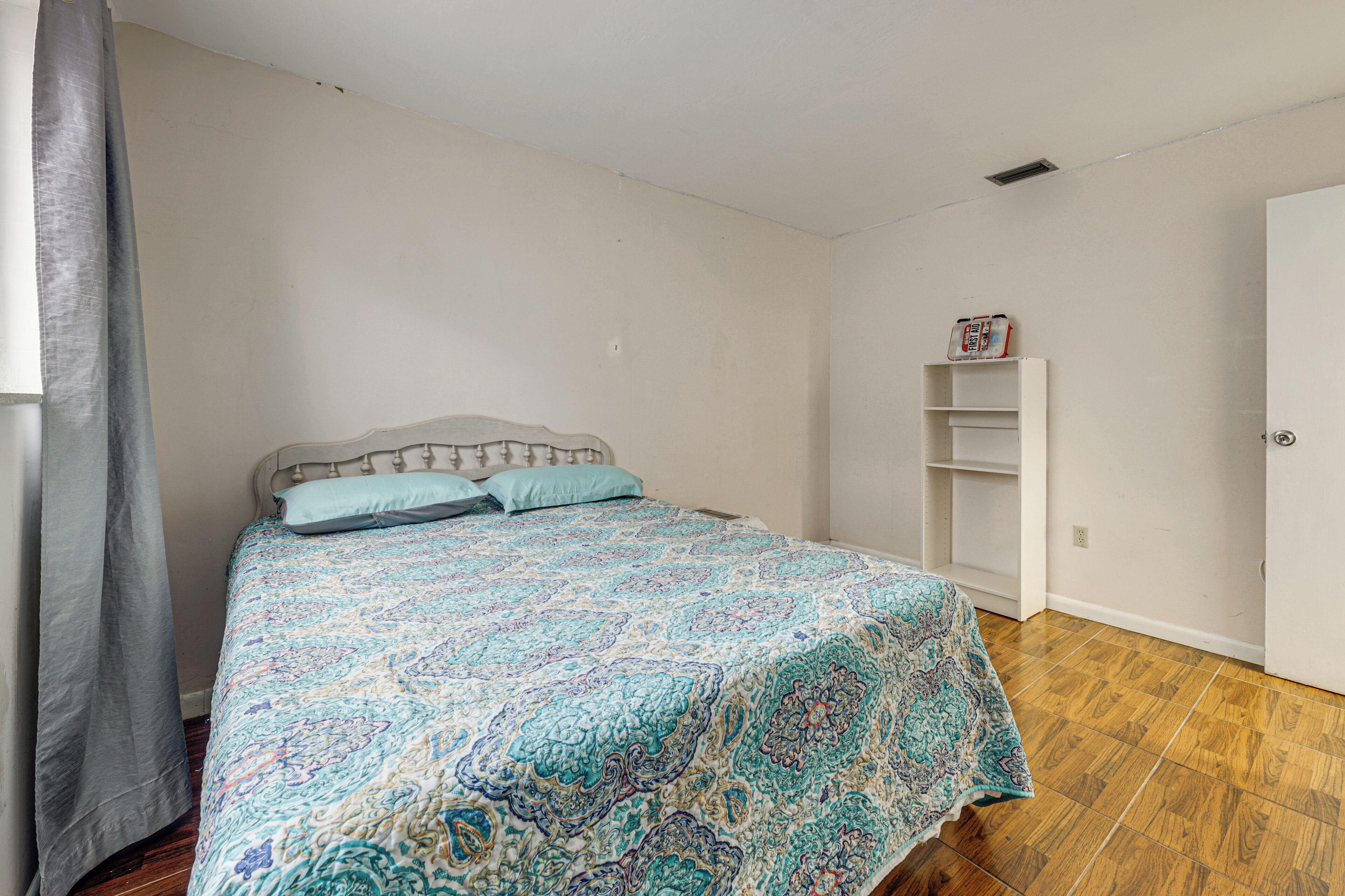 Une chambre à coucher avec un lit, une armoire et une étagère sur laquelle sont posés divers objets.