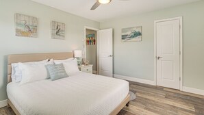 A bedroom with a bed, a ceiling fan, and artwork on the walls. - 8 Mi to Beaches: Getaway w/ Pool in Panama City! (Panama City)