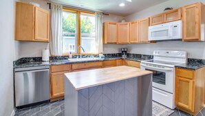 Una cocina moderna con armarios de madera, microondas integrado y lavavajillas.