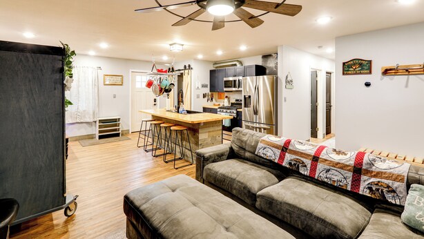 A modern kitchen with a central island, bar stools, and a ceiling fan. - Walk to Dtwn: Dog-friendly Retreat in Fairbanks! (Fairbanks)