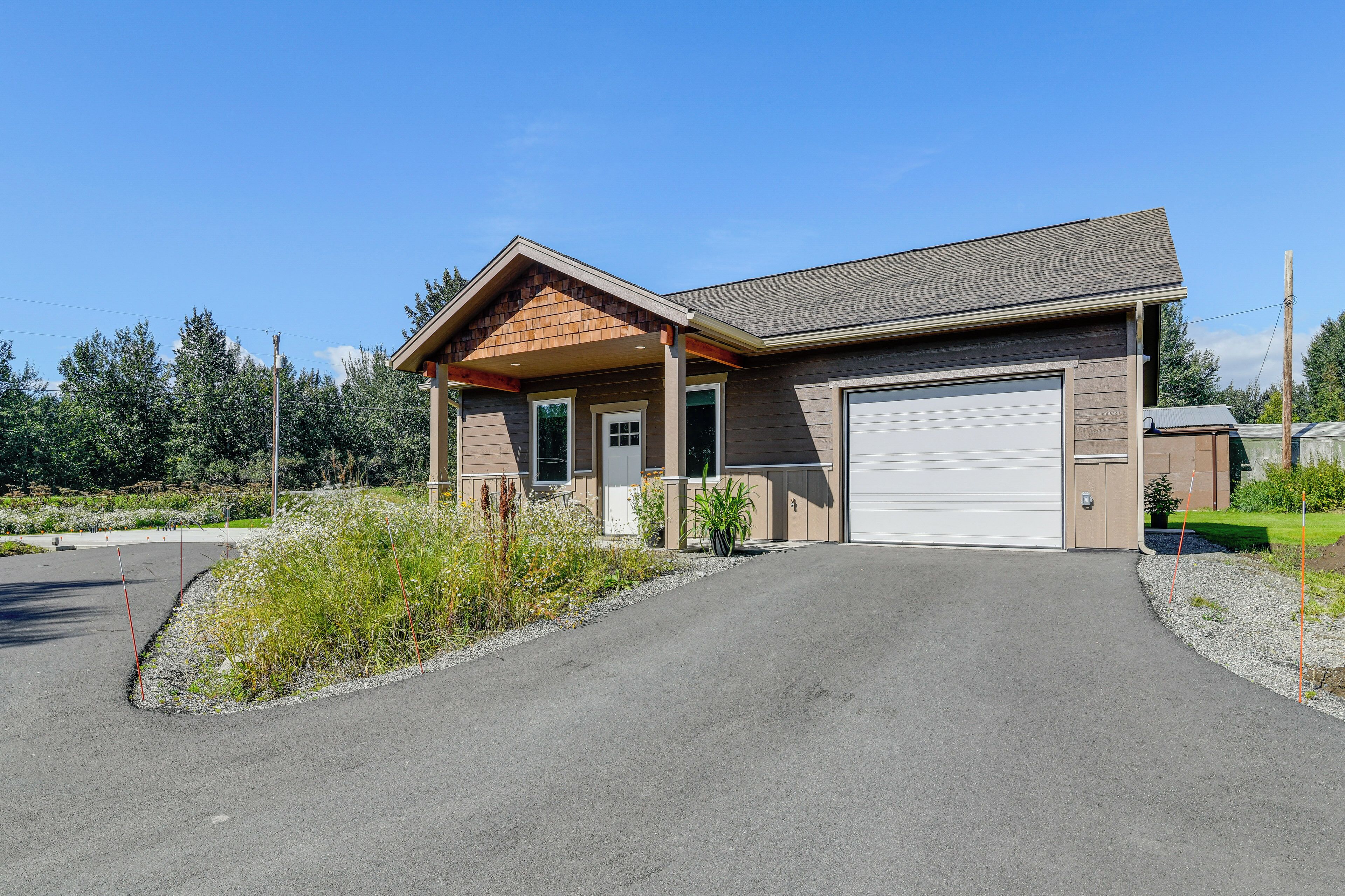 A single-story house with a garage, a covered porch, and a driveway leading to the entrance.