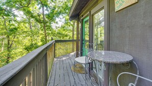A wooden deck with a table and chairs, a green door, and a sign that reads "The Clubhouse".