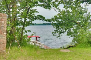 A lakeside dock with a boat and a stone wall. - Pet-friendly Lakeside Cabin w/ Dock & Fire Pit (Vergas)