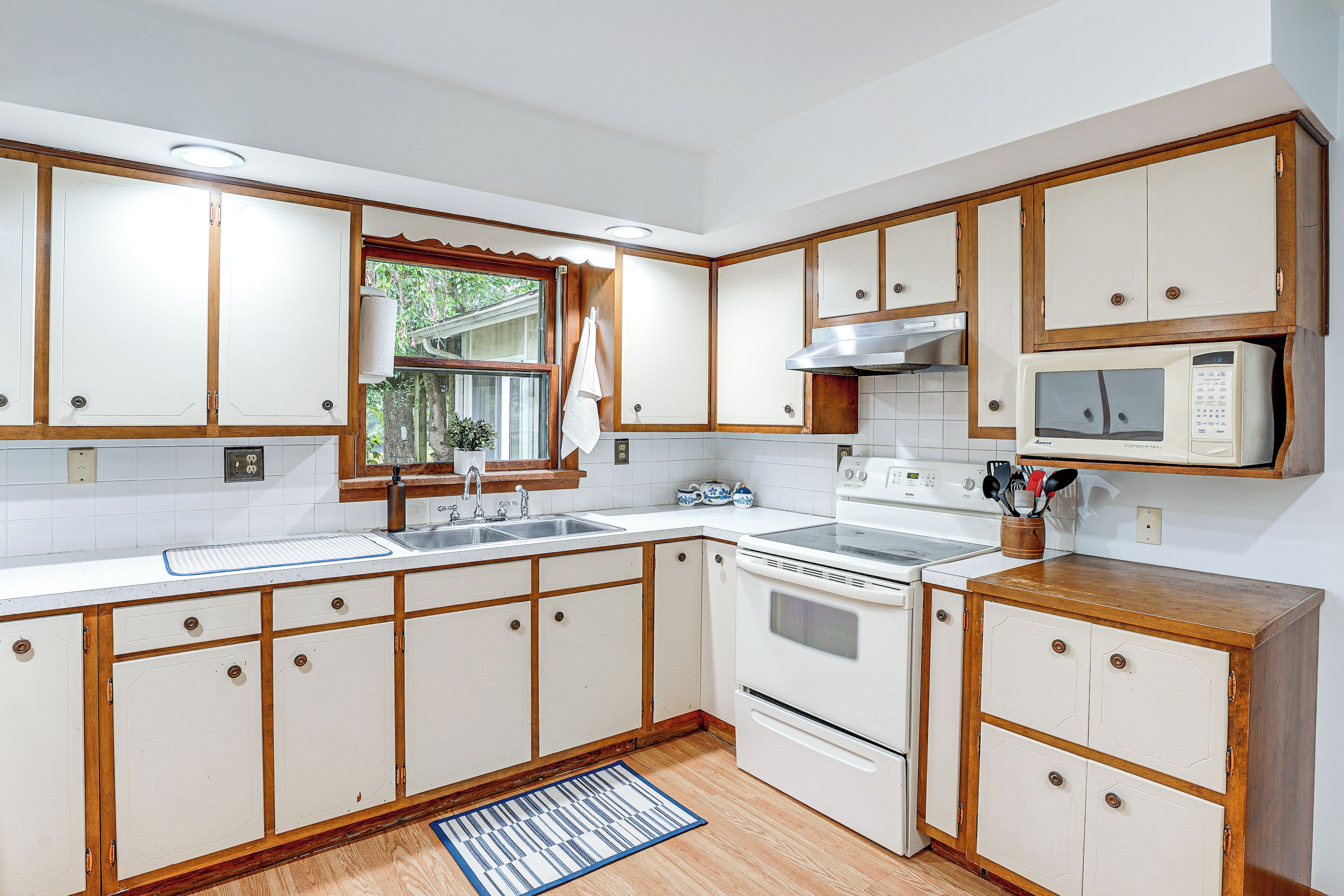 A kitchen with wooden cabinets, a microwave, and a stove.