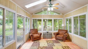 A sunroom with two leather chairs, a patterned rug, and a vintage trunk. - Quiet Retreat in Bluffton: Fish, Hike & Golf (Bluffton)