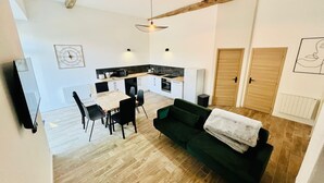 Um apartamento moderno com área de jantar, cozinha e sala de estar.
