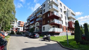 A multi-story residential building with balconies and a paved driveway. - RentPlanet - Apartament Klonowa (Kołobrzeg)