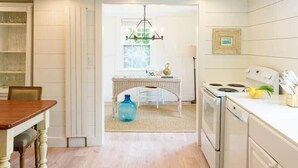 Une cuisine avec une table à manger, un lustre et une cuisinière.