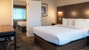 Quarto de hotel com cama, escrivaninha e cadeira.