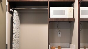 Casa de banho compacta com chuveiro, sanita e um pequeno frigorífico.