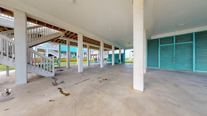 A covered outdoor area with a staircase, benches, and a view of a building in the background.