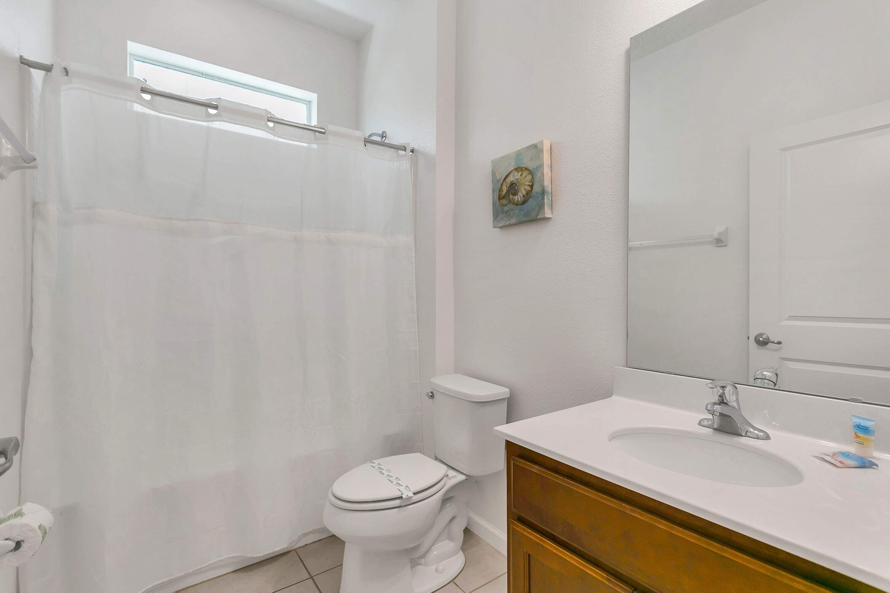 Une salle de bain avec des toilettes, un lavabo et un rideau de douche.