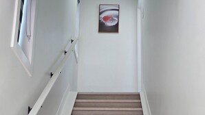 Una escalera con escalones de madera y barandillas blancas.