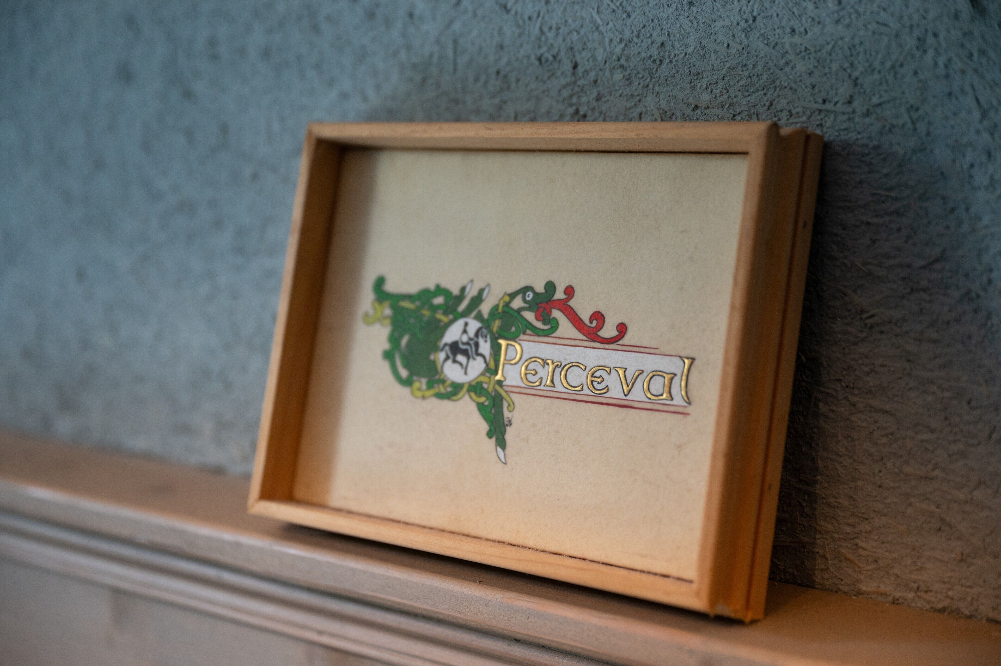 A framed sign with the word 'Perceval' and a decorative emblem.