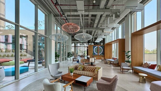 A spacious lobby with large windows, modern furniture, and a central art piece. - Modern 1BR at Collective | Dubai Hills Mall Nearby (Dubai)