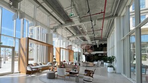 A spacious lobby with a central seating area, large windows, and a modern design. - Modern 1BR at Collective | Dubai Hills Mall Nearby (Dubai)
