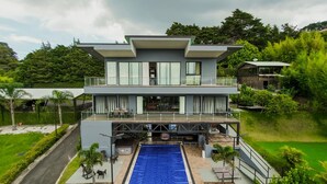 Un bâtiment moderne à deux étages, doté d’une piscine sur le toit et d’un espace extérieur aménagé pour se détendre.
