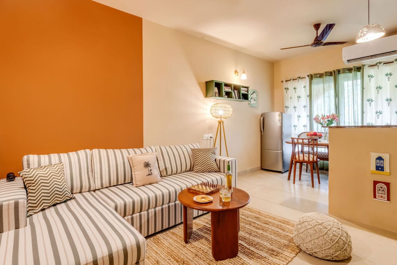 A living room with a striped sofa, a round wooden coffee table, and a floor lamp.
