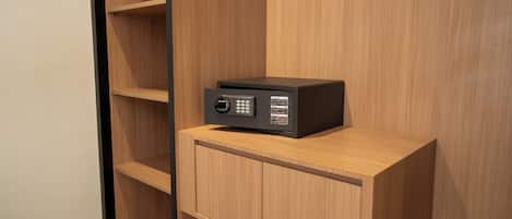 A black electronic device on a wooden cabinet in a room with wooden walls and shelves.