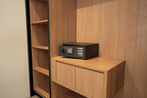 A black electronic device on a wooden cabinet in a room with wooden walls and shelves. - TheNomad Canggu (Canggu)