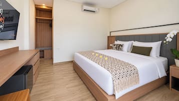Une chambre d’hôtel équipée d’un lit, d’un bureau, d’une armoire et d’un appareil de climatisation.
