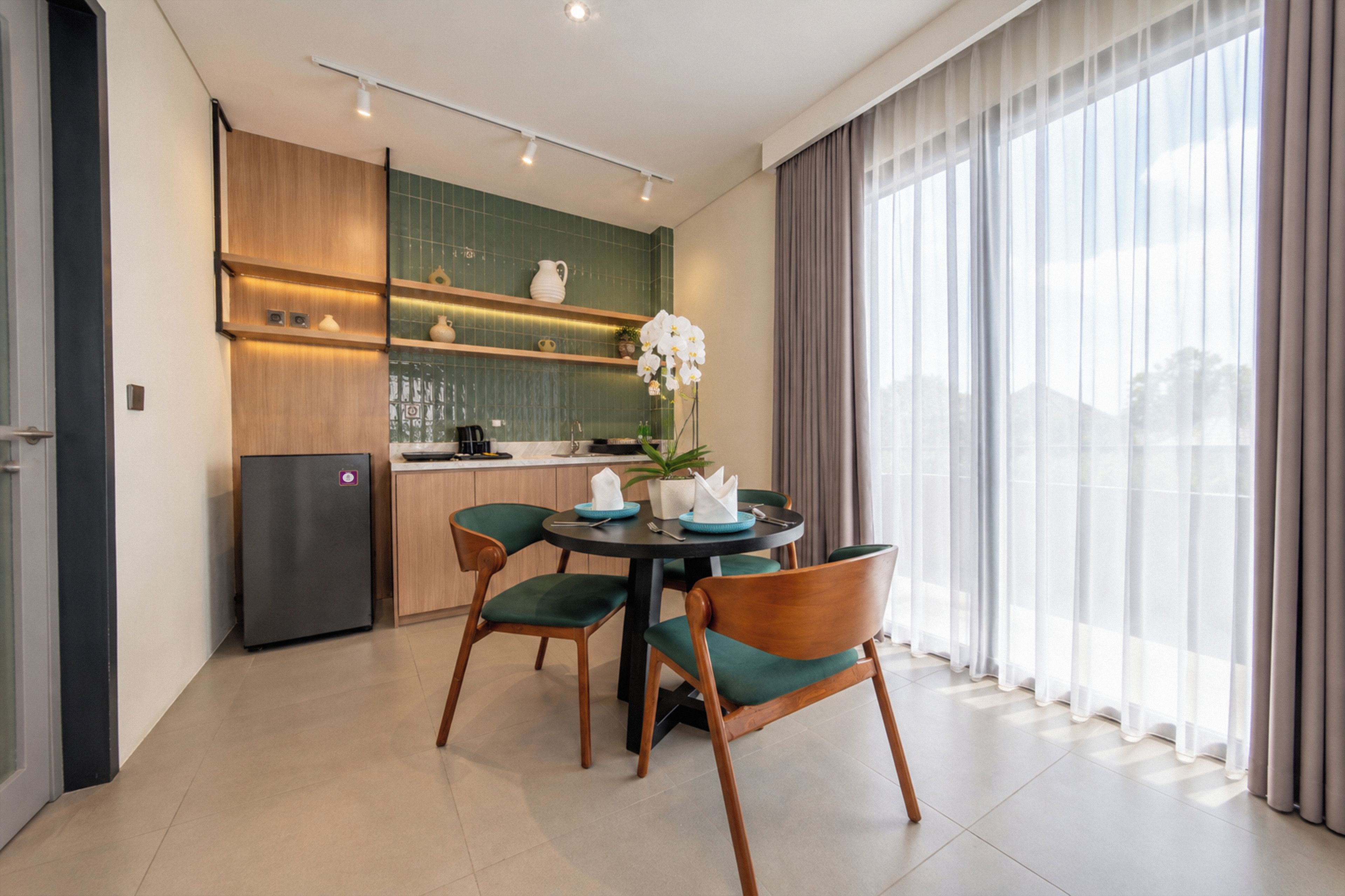 Una cocina moderna con comedor, que incluye un refrigerador, armarios y una mesa con sillas.