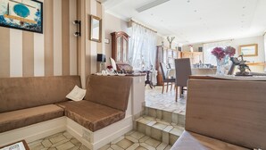 Una sala de estar con un sofá, un comedor con una mesa y sillas, y una escalera.