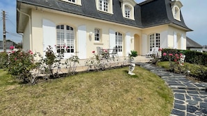 Ein großes, zweistöckiges Haus mit einem Kiesweg, der zum Eingang führt.