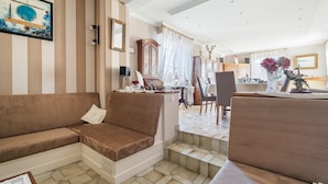 Ein Wohnzimmer mit einer Couch, einem Essbereich mit Tisch und Stühlen sowie einer Treppe.