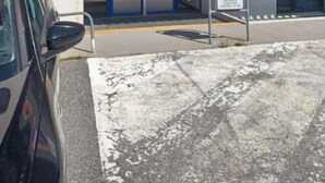 Un edificio con puerta de entrada azul, un letrero de no estacionamiento y un cartel que indica el nombre 'ARMAZAN'.