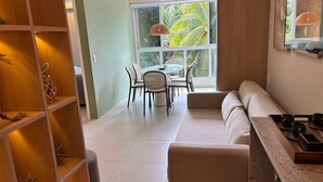 A modern interior with a dining area, a sofa, and a kitchen counter. - Mila Rooftop (Tamandaré)