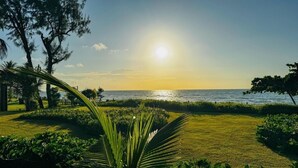 A well-maintained garden with a view of the sea at sunset. - Mila Rooftop (Tamandaré)