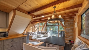 Un intérieur chaleureux et rustique, avec un espace repas, une cuisine et un coin salon.