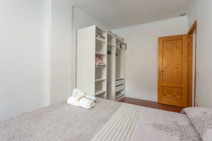 A bedroom with a bed, a wardrobe, and a wooden door.