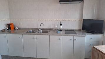 Cafetera o tetera, frigorífico, microondas y placa de cocina