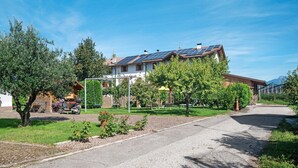 Une maison d’habitation dotée de panneaux solaires, d’une allée pavée et d’un jardin.