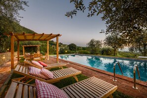 A poolside area with lounge chairs and a pergola. - Villa Giannello Farmhouse (Capannori)