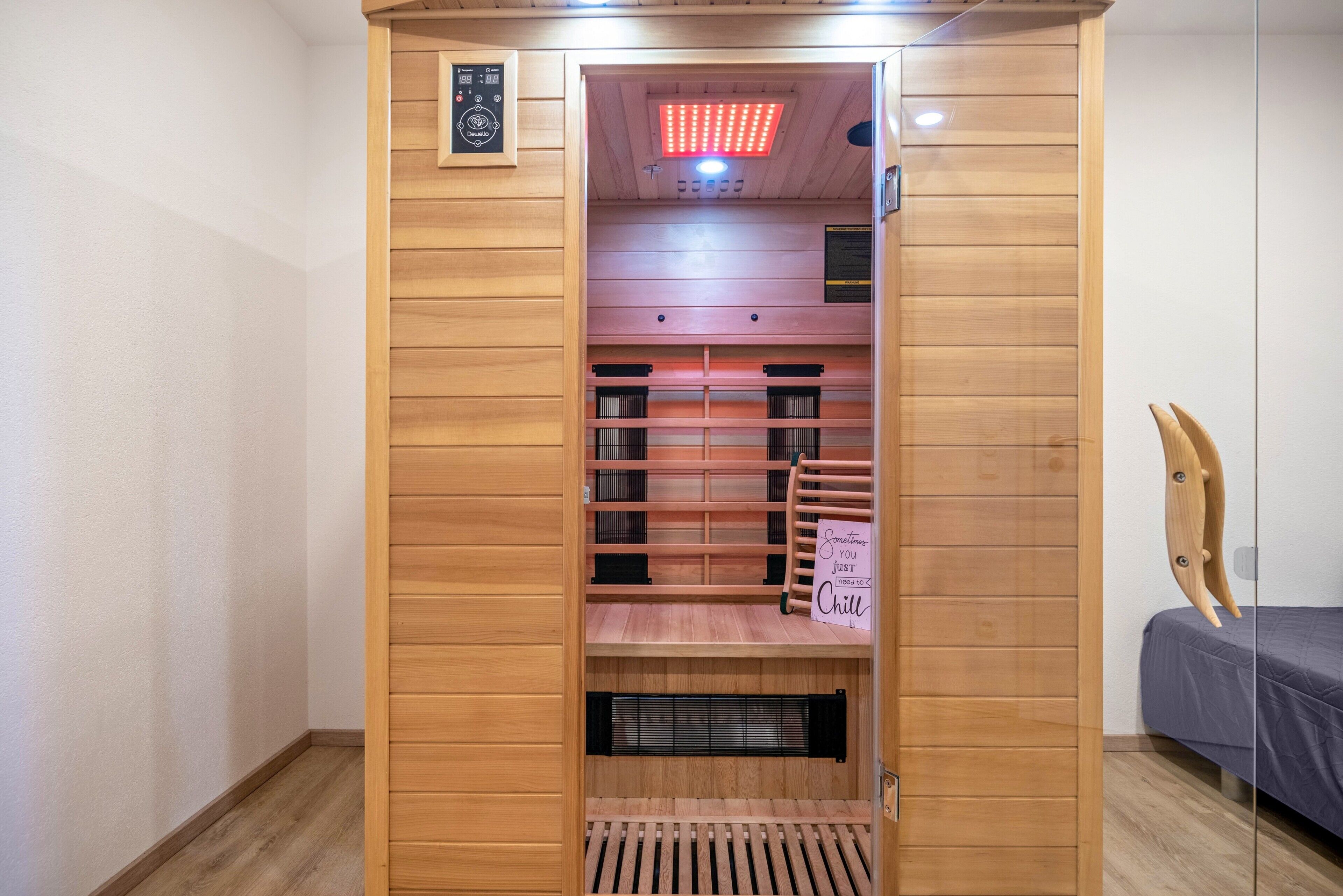 Un sauna con paredes de madera, un banco y un cartel que dice 'Something just cool'.