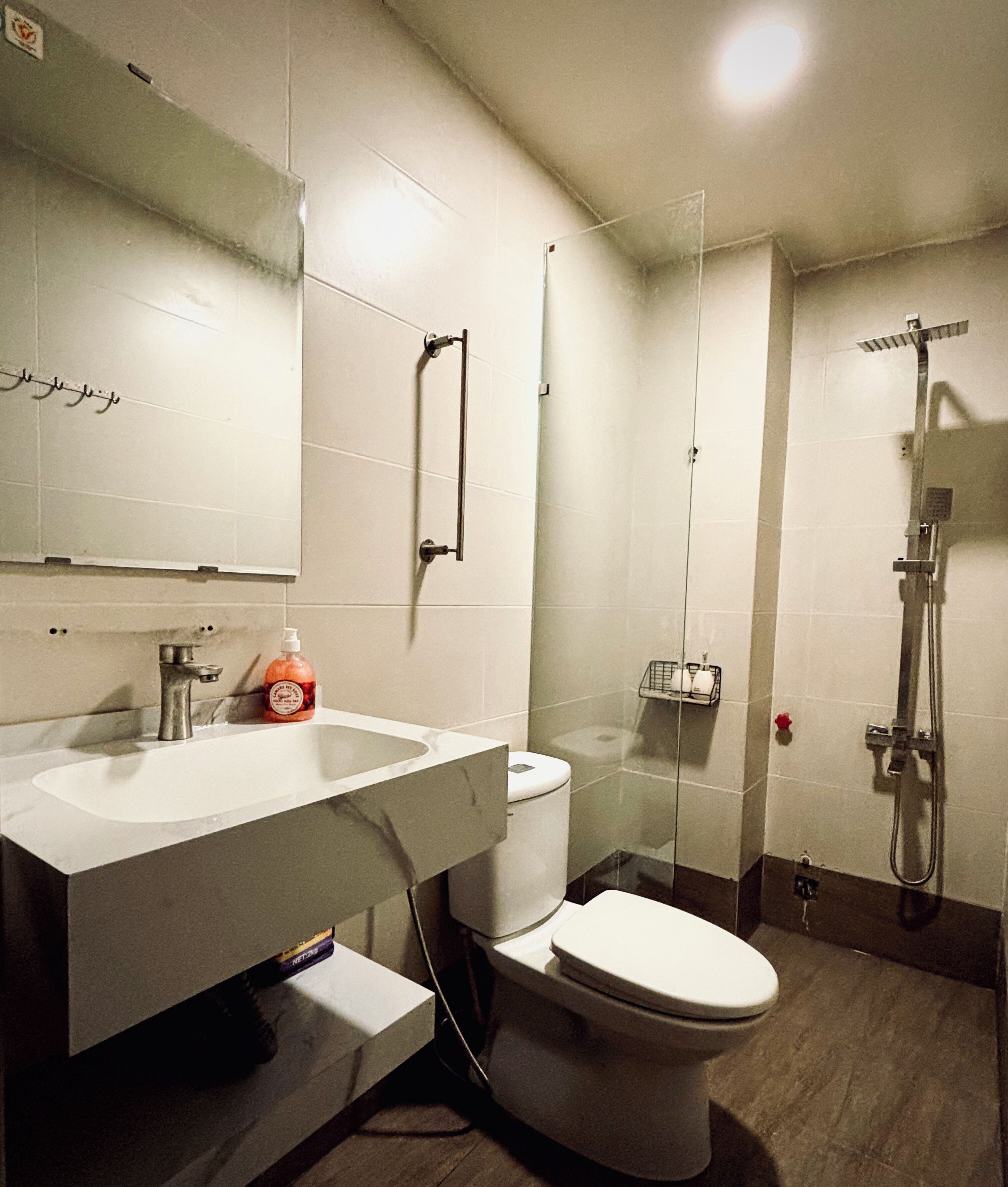 A bathroom with a sink, toilet, and shower.