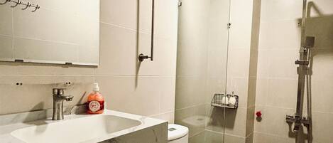 A bathroom with a sink, toilet, and shower.