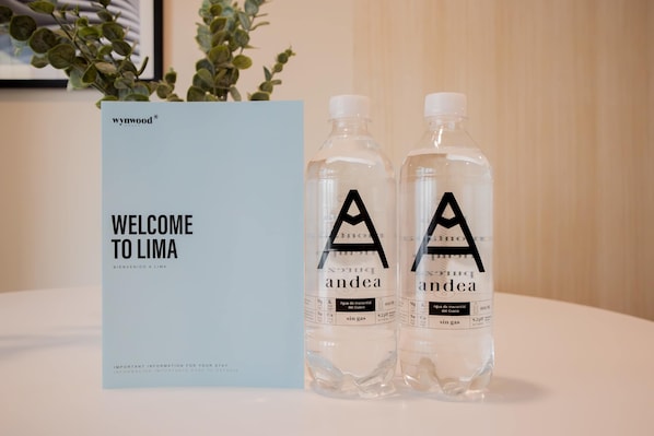 A welcome sign and two bottles of water labeled 'andea' with a logo, placed on a table.