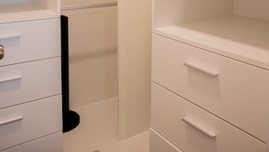 A walk-in closet with open shelves, a hanging rod, and drawers. - w Charming 2BR Stay in Miraflores (Lima)