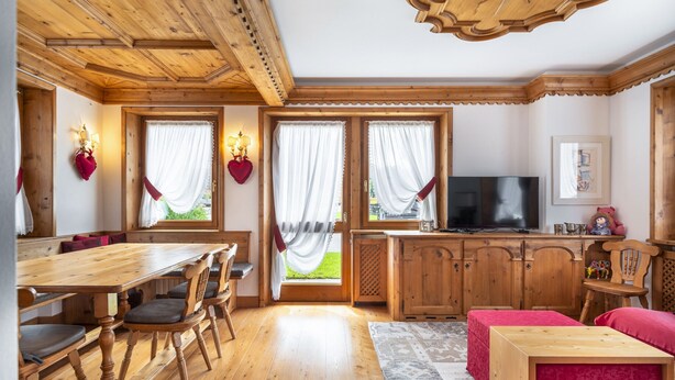 A wooden interior with a dining area, kitchen, and seating.