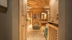 A wooden interior with a hallway leading to a bedroom.