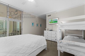 Une chambre à coucher comprenant un lit, une commode, une coiffeuse et un lit superposé.